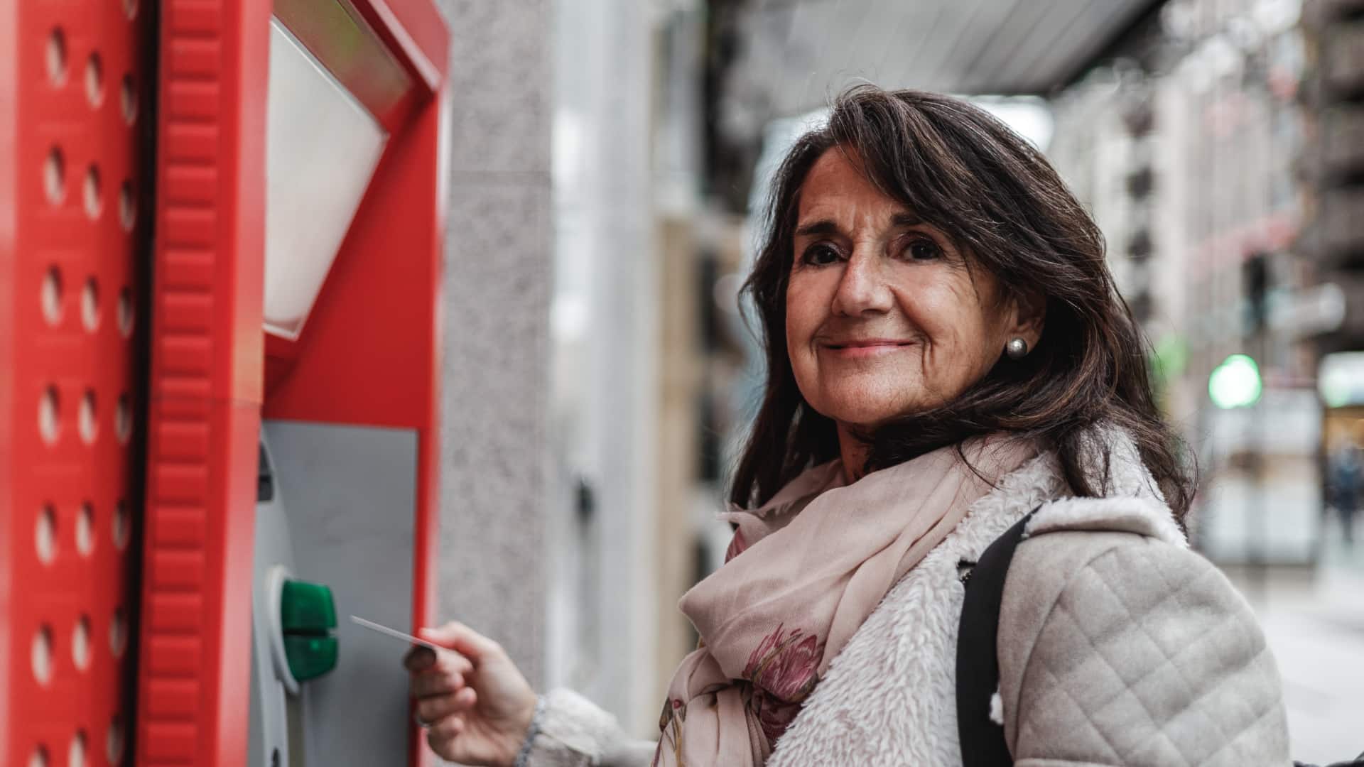 Mujer saca el dinero del paro de un cajero automático